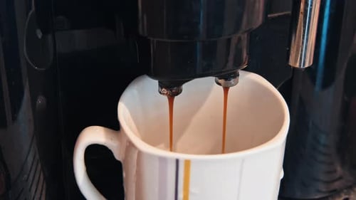 Coffee being poured from machine into mug