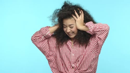 Woman Expressing Frustration with Curly Hair in Studio