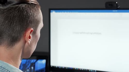 Rear View Cropped Shot of a Computer Programmer Working Late in IT Office