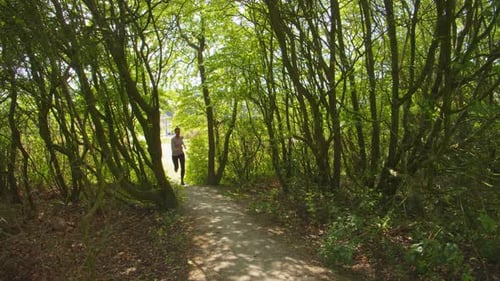 Female Jogger Entering Forest