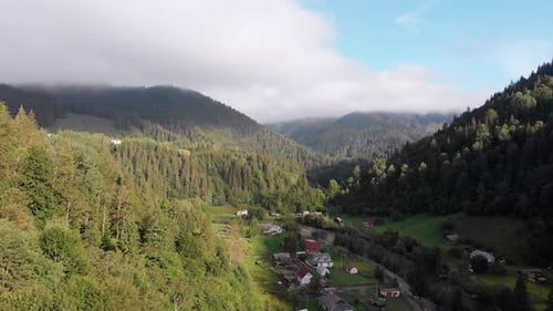 Aerial View of the Carpathian Mountain Valley with Green Meadows and Trees