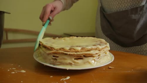 Homemade Layer Cake Being Iced in Kitchen