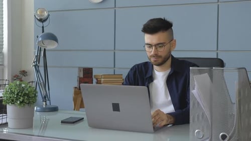 Young Adult Working on Laptop in Office