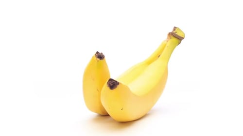 Banane jaune rotative isolée sur boucle blanche