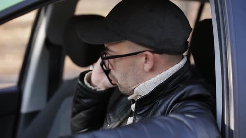 Man Inside Car Takes Photos with Professional Camera