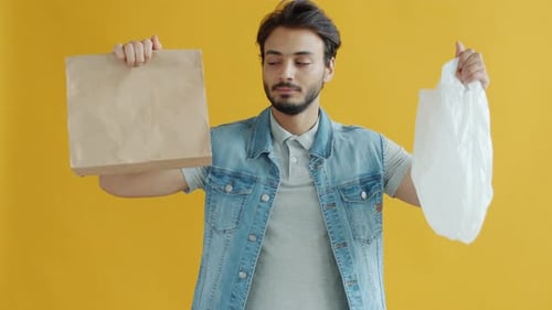 Retrato en cámara lenta de un chico de Oriente Medio que elige una bolsa de papel en lugar de plástico y sonríe