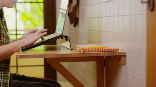 Freelancerin in Freizeitkleidung beim Tippen auf Laptop