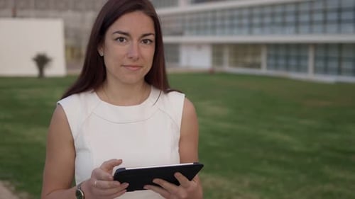 Woman with Tablet Standing Outside Office Building