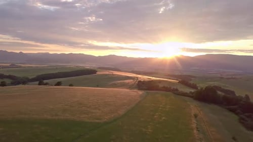 Scenic Sunset Over Rolling Hills and Fields