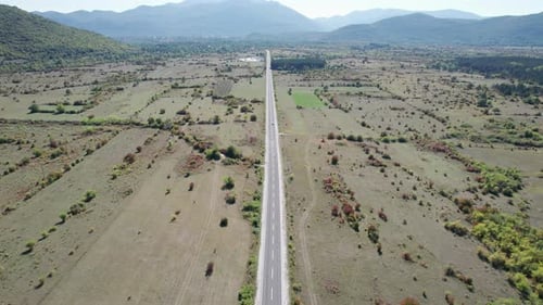 Aerial View Empty Asphalt Road on the Plateau Between Green Fields Highland Way