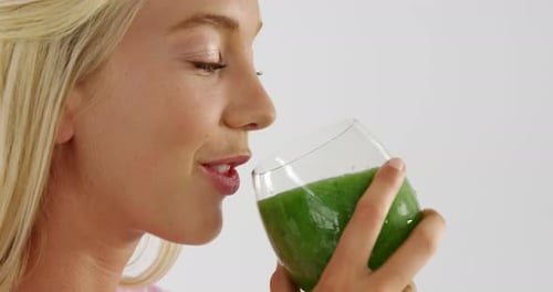 Woman Drinks Green Smoothie for Health and Fitness
