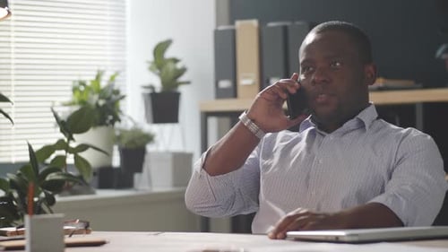 Professional Man Talking on Cell Phone in Office
