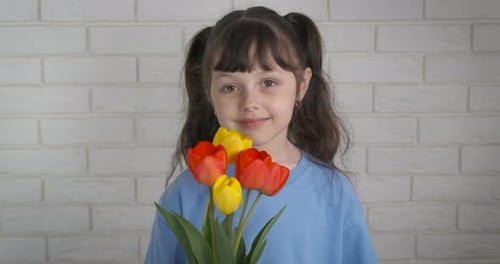 Smiling Child Holding a Bouquet of Tulips