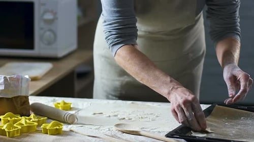 Baker Cutting Out Shapes From Rolled Out Ginger Cookies Dough With Star Cutters