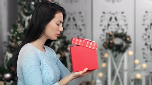 Woman Excitedly Opens a Christmas Present