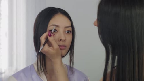 Das
Gesicht des jungen asiatischen Models während des Make-up-Prozesses.