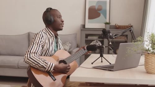Man Plays Guitar in Living Room Recording Studio