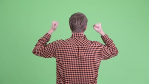 Rear View of Happy Young Hipster Man with Fists Raised