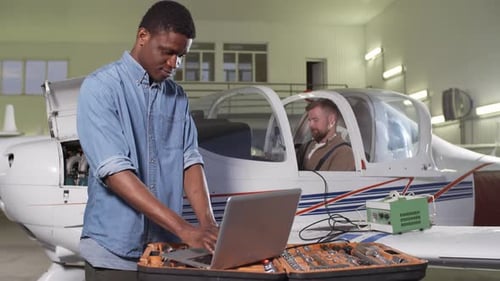 Multiethnic Maintenance Technicians Working in Hangar