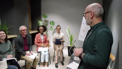 Cheerful Senior Executive Leading Business Seminar with Multiethnic Employees