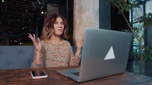 Happy Blogger Girl Talking on Laptop Sitting in Cafe