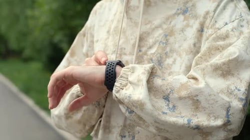Person Checking Smart Watch Outdoors in Urban Setting
