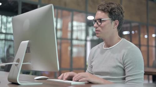 Ehrgeiziger junger Mann arbeitet am Computer
