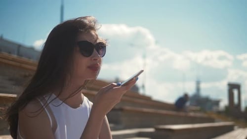 Young Woman Using Smartphone Voice Features Outside