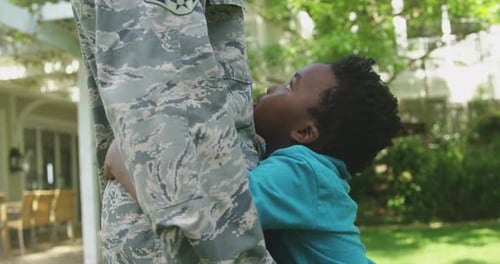 Boy Hugs Military Member with American Flag