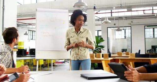 Business Woman Leads Presentation to Team at Office