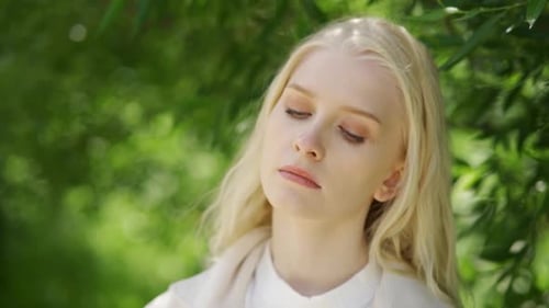 Woman Removing Face Mask Smelling a Flower