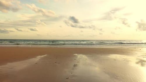 4K Aerial view Group of people surfing in the sea ay summer sunset