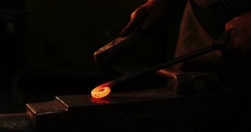 Blacksmith Shapes Glowing Metal Ring on Anvil