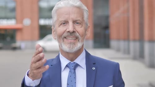 Older Man in Blue Suit Talking and Gesturing