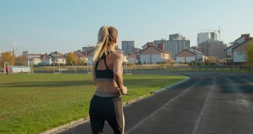 Strong Fitness Girl Running in Stadium. She Is Celebrating the End of Her Workout