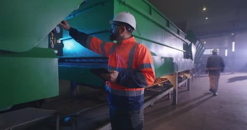 Male Engineer Checking Valve on Industrial Machinery