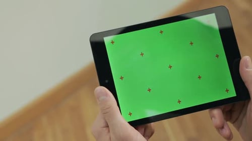 Male Hand Holding Tablet with Green Screen. Man Reading Ebook with Green Screen