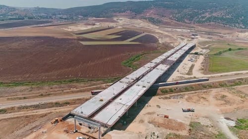 Aerial footage of large highway construction project with tunnels and bridges