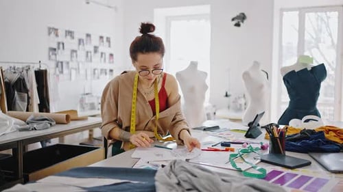 Young Lady in Eyeglasses Choosing Pencil and Coloring Dress Sketches Working at Workshop Tracking
