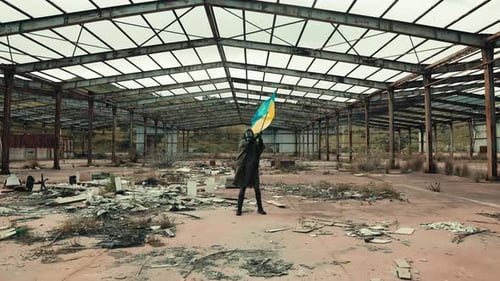 Adult with Ukrainian Flag in Derelict Warehouse