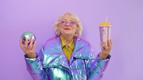 Senior Woman Posing With Disco Ball and Drink