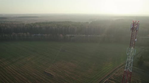 Telecommunications Tower on the Background of a Freight Train in the Countryside
