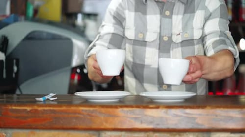 O
barista serve duas xícaras de café. Conceito de serviços e bebidas.