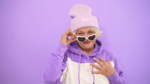 Happy, Positive Old Woman Having Fun at a Photo Shoot, Flirting on Camera in the Studio