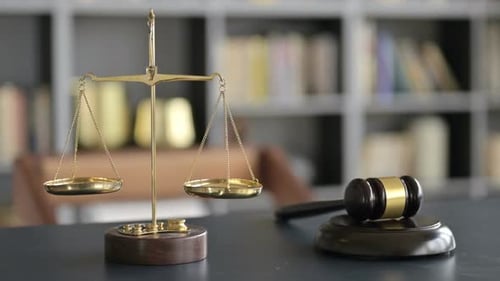 Gavel and Gold Brass Balance Scale on Lawyer Office Table