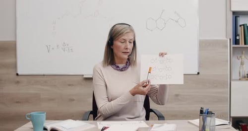 Woman Explains Chemical Diagrams at Desk