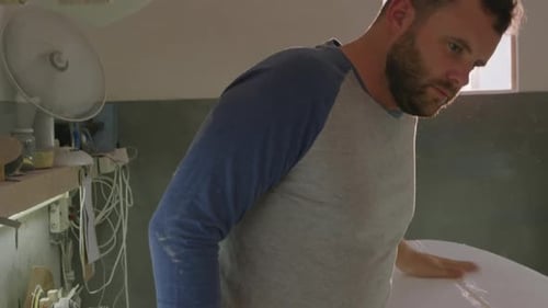 Male surfboard maker in his workshop