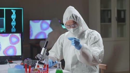 Scientist in Hazmat Suit Using Microscope in Lab