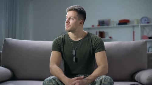 Upset Male Soldier Sitting on Sofa and Thinking About Life Problems Sadness