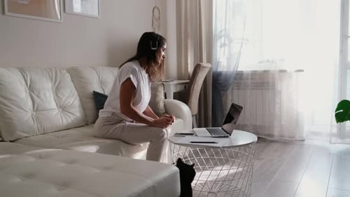 Woman Attending Video Conference on Laptop at Home